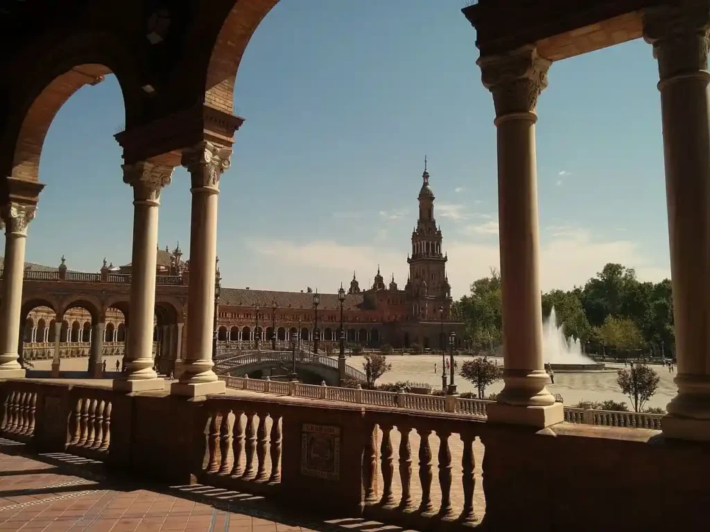 Consejos para viajar a Sevilla: vista de la Plaza de España, su fuente central y la Torre Sur desde los arcos de la galería porticada