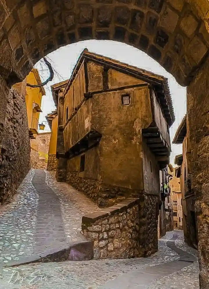 Qué ver en Albarracín: la icónica Casa de la Julianeta enmarcada a través del arco del Portal de Molina en Teruel.