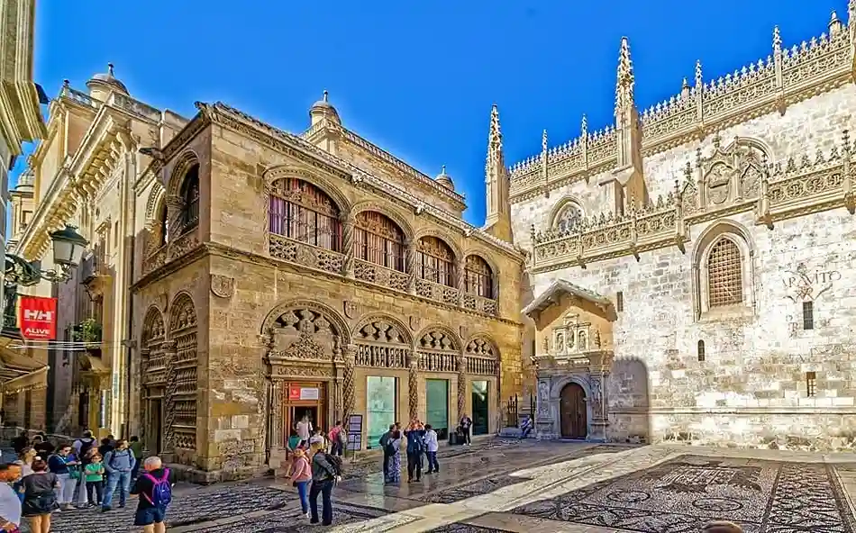 Fachada plateresca de la Lonja y portada gótica de la Capilla Real de Granada con empedrado tradicional.