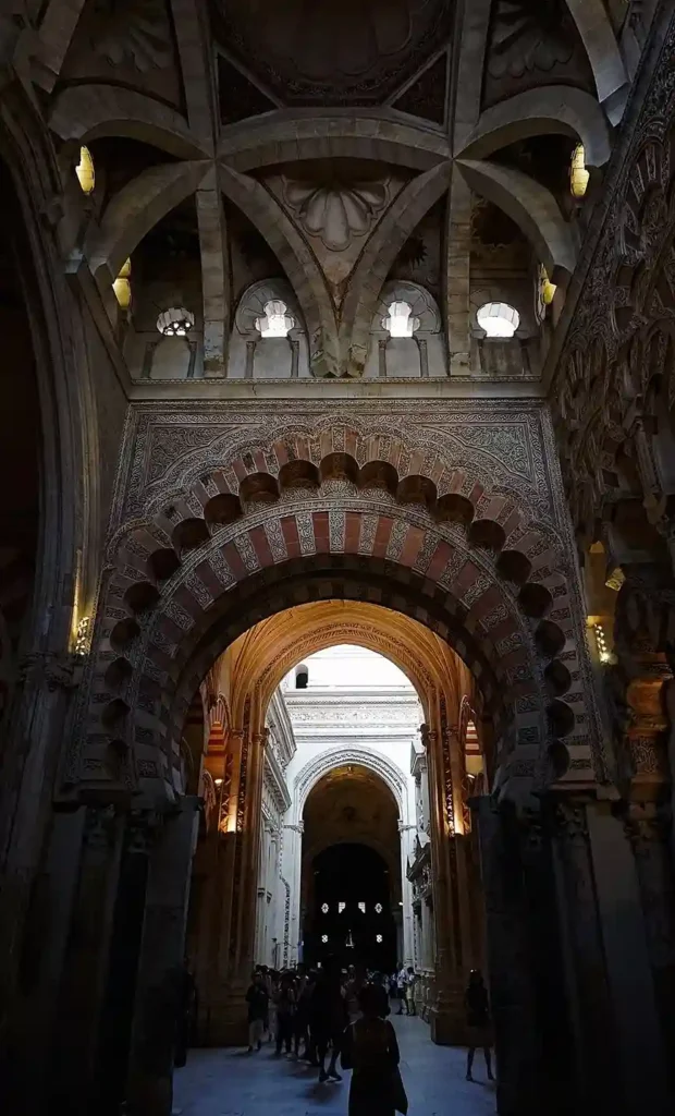 Contraste de estilos arquitectónicos en la Mezquita de Córdoba: arco islámico polilobulado y nave de la catedral al fondo