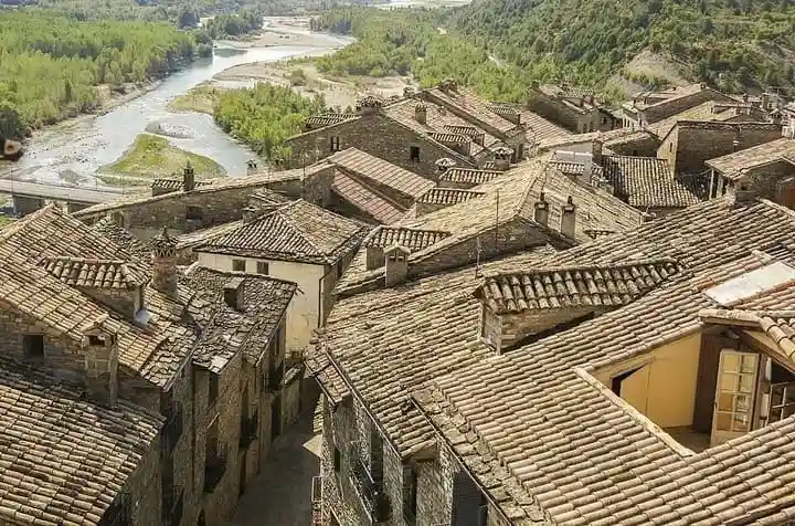 Tejados tradicionales de piedra de Aínsa y curso del río Cinca desde el campanario de Santa María
