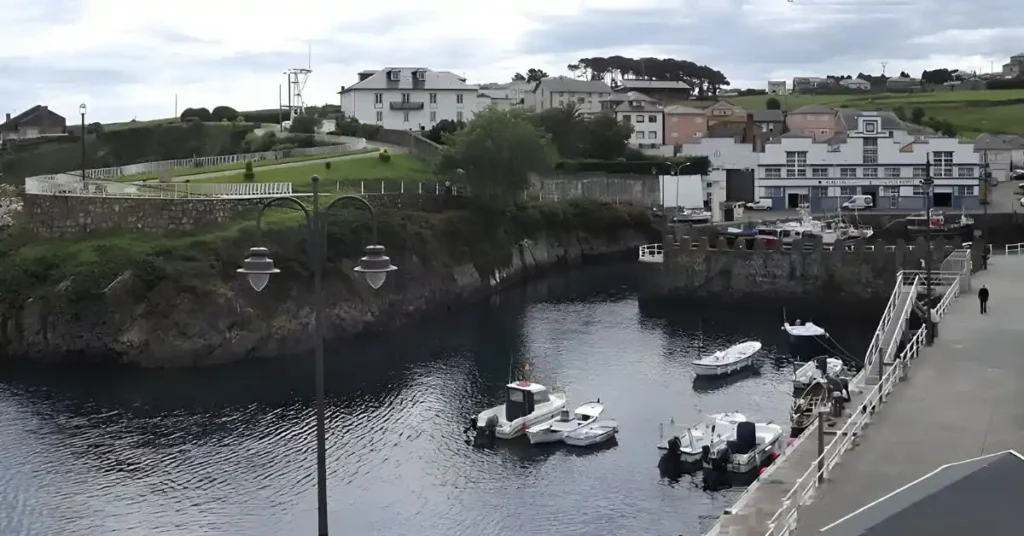 El puerto pesquero tradicional, uno de los lugares imprescindibles que ver en Puerto de Vega con barcos amarrados y la lonja