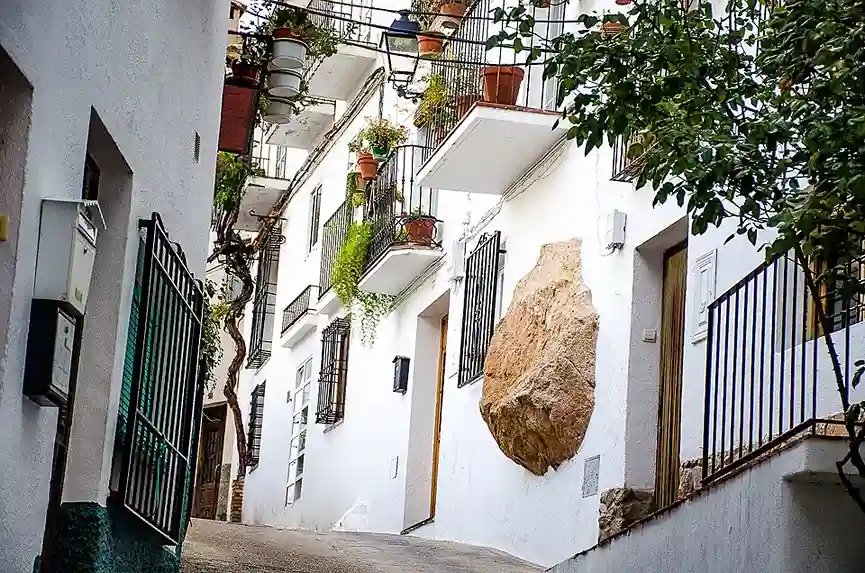 Calle empinada típica del casco histórico de Cazorla con fachadas blancas y roca integrada