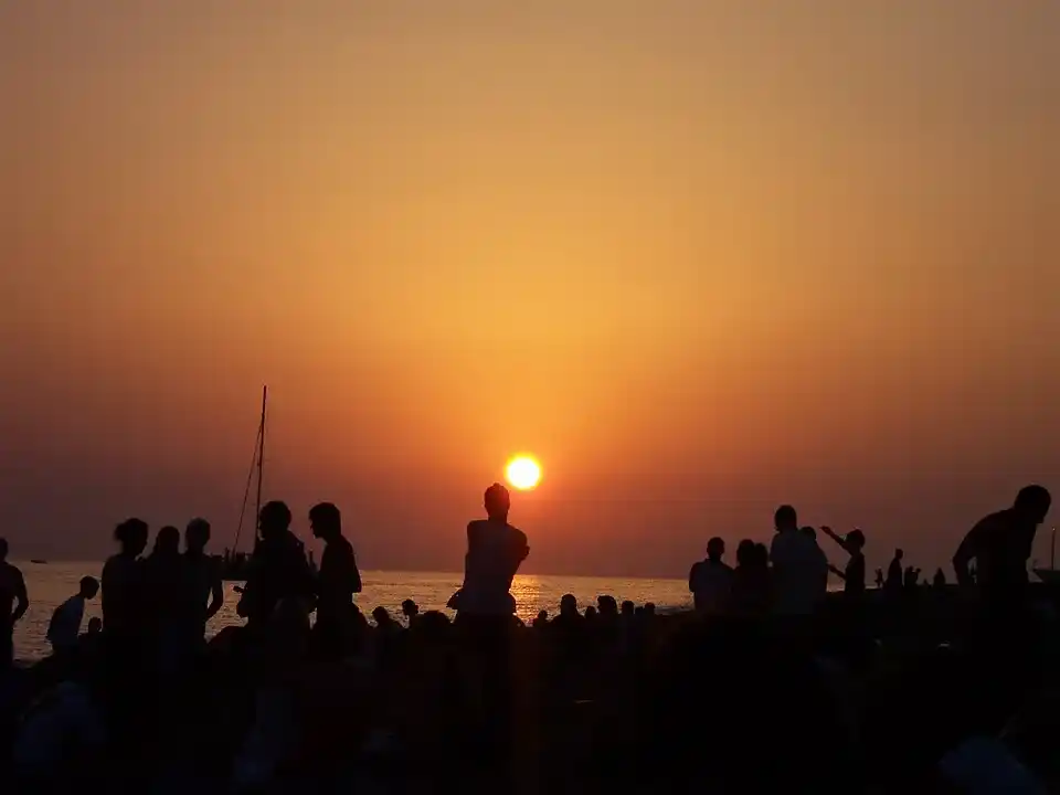 Multitud contemplando la puesta de sol en Ibiza desde la orilla frente a Café del Mar en San Antonio.