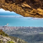 Vista de la costa y población de Sant Carles de la Ràpita enmarcada por el arco natural de la Foradada del Montsià