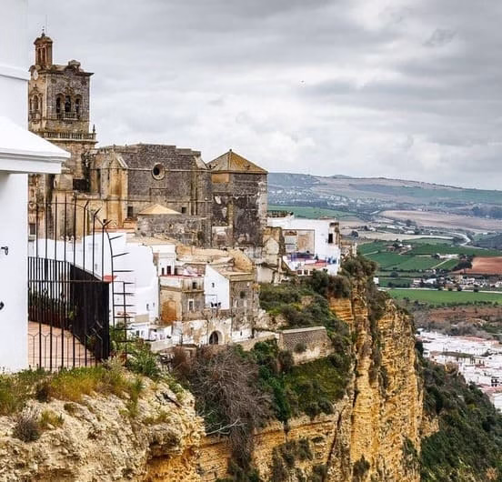 Vista panorámica de Arcos de la Frontera, pueblo blanco de Cádiz situado sobre un acantilado con su iglesia histórica y casas blancas típicas andaluzas sobre el valle del Guadalete