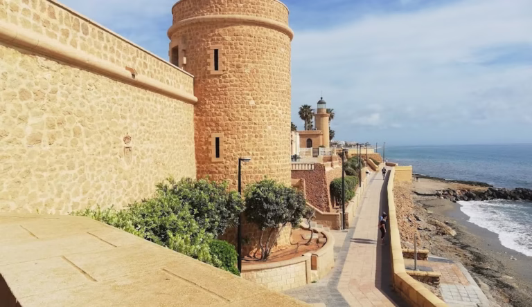 Vista del paseo marítimo y castillo histórico en un pueblo bonito cerca de Roquetas de Mar, junto al mar Mediterráneo