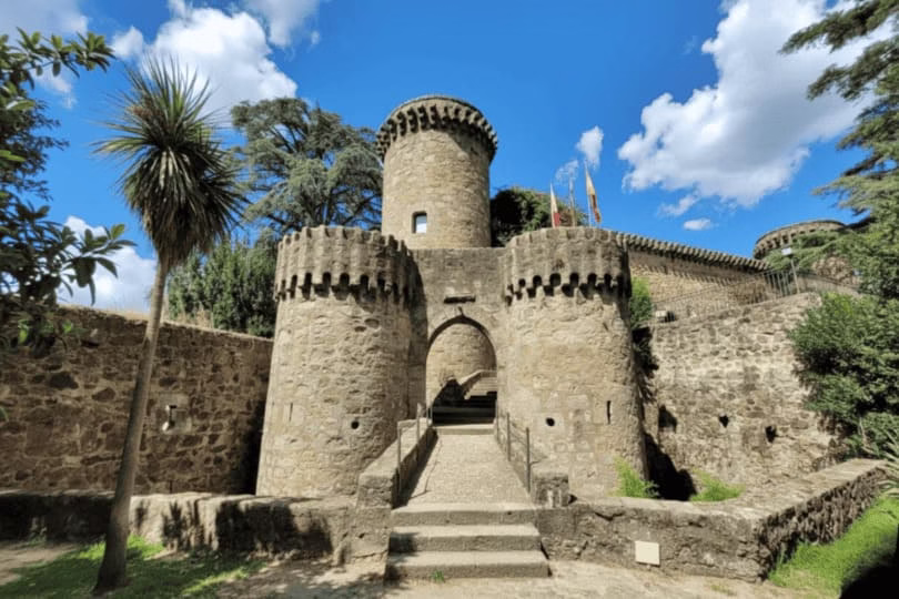 Castillo de los Condes de Oropesa en Toledo, vista exterior con torreones y entrada principal bajo cielo azul.