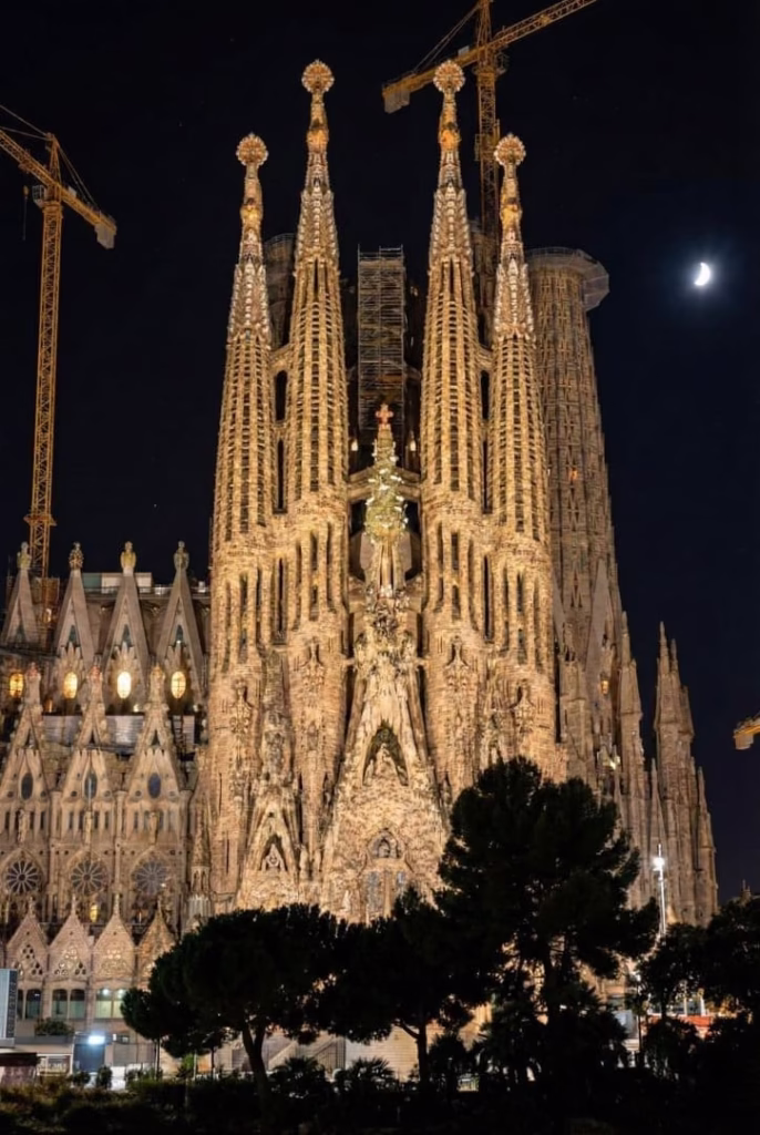 Fachada de la Sagrada Familia iluminada de noche en Barcelona.